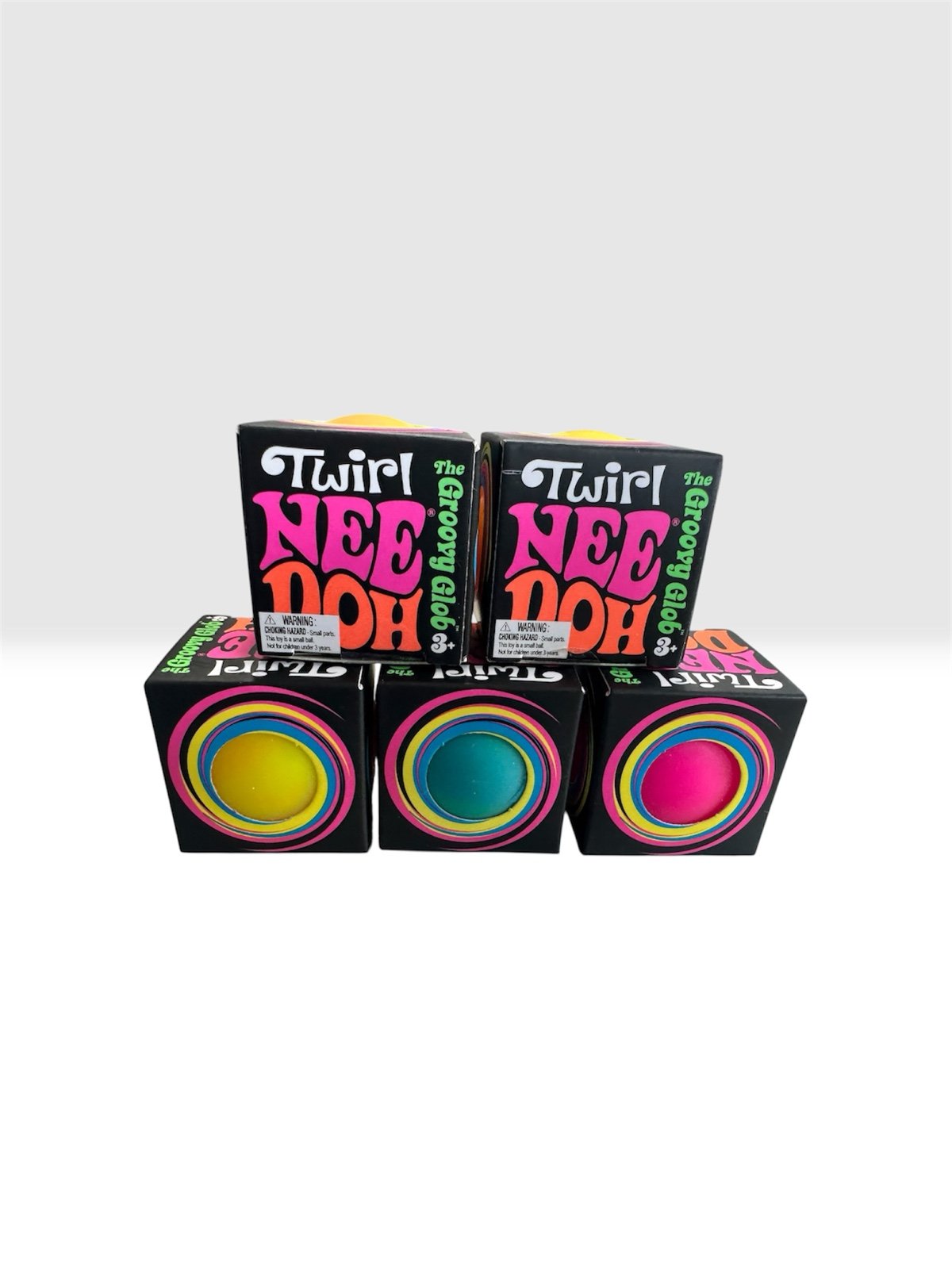 Three NeeDoh Twirl The Groovy Glob boxes showing yellow, blue and pink globs